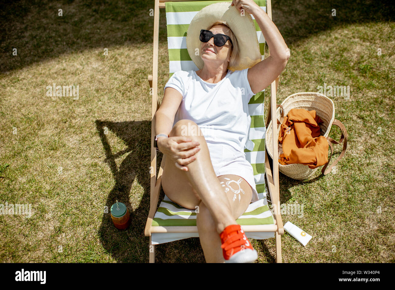 Carefree mature woman sunbathing hi-res stock photography and images ...