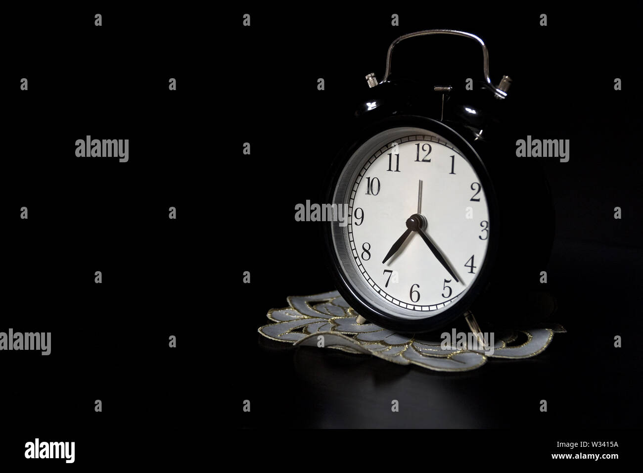 Classic mechanical alarm clock on dark background. Low key Stock Photo