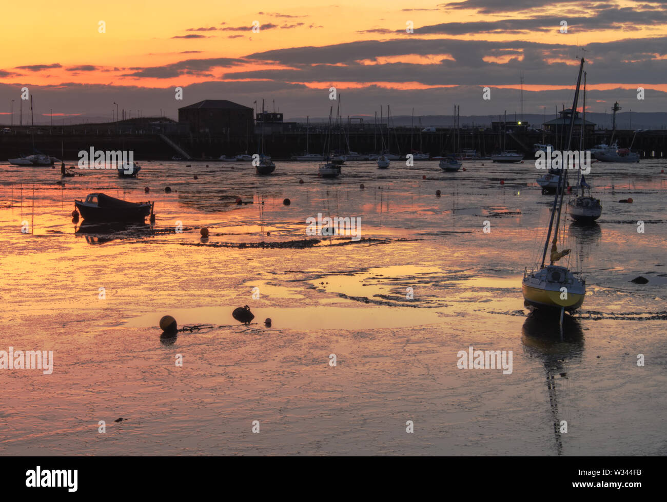 Edinburgh, Scotland / United Kingdom -May 11 2019: The harbour in Granton, Edinburgh, UK at low tide with a number of sailing boats resting on the ban Stock Photo