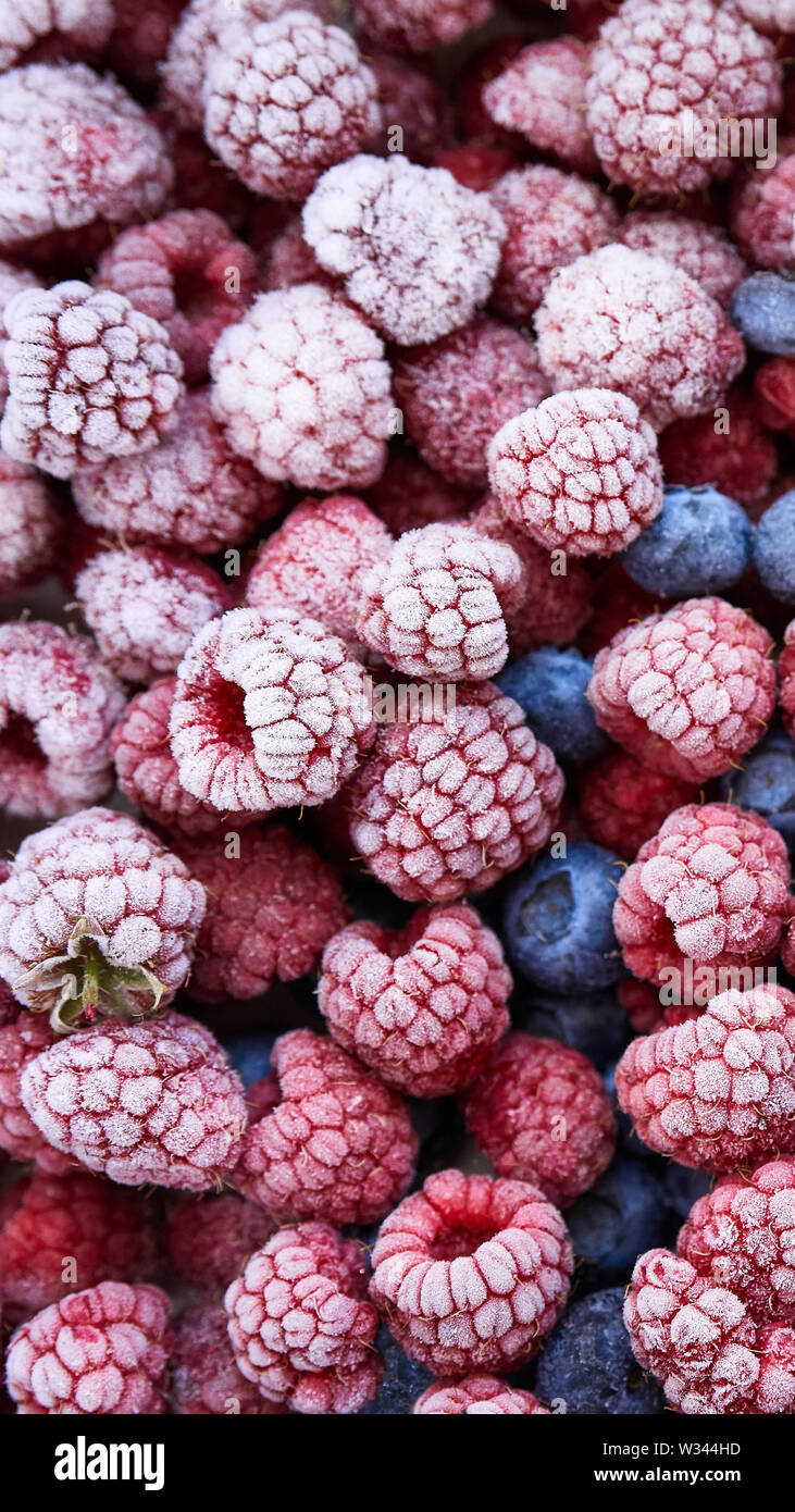 Background of frozen berries. Top view of raspberries and blueberries. Stock Photo