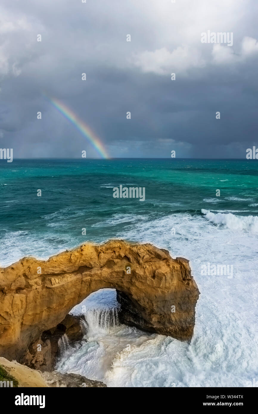 Beautiful view of the Arch rock along the Great Ocean Road, Australia, with a rainbow in the background Stock Photo