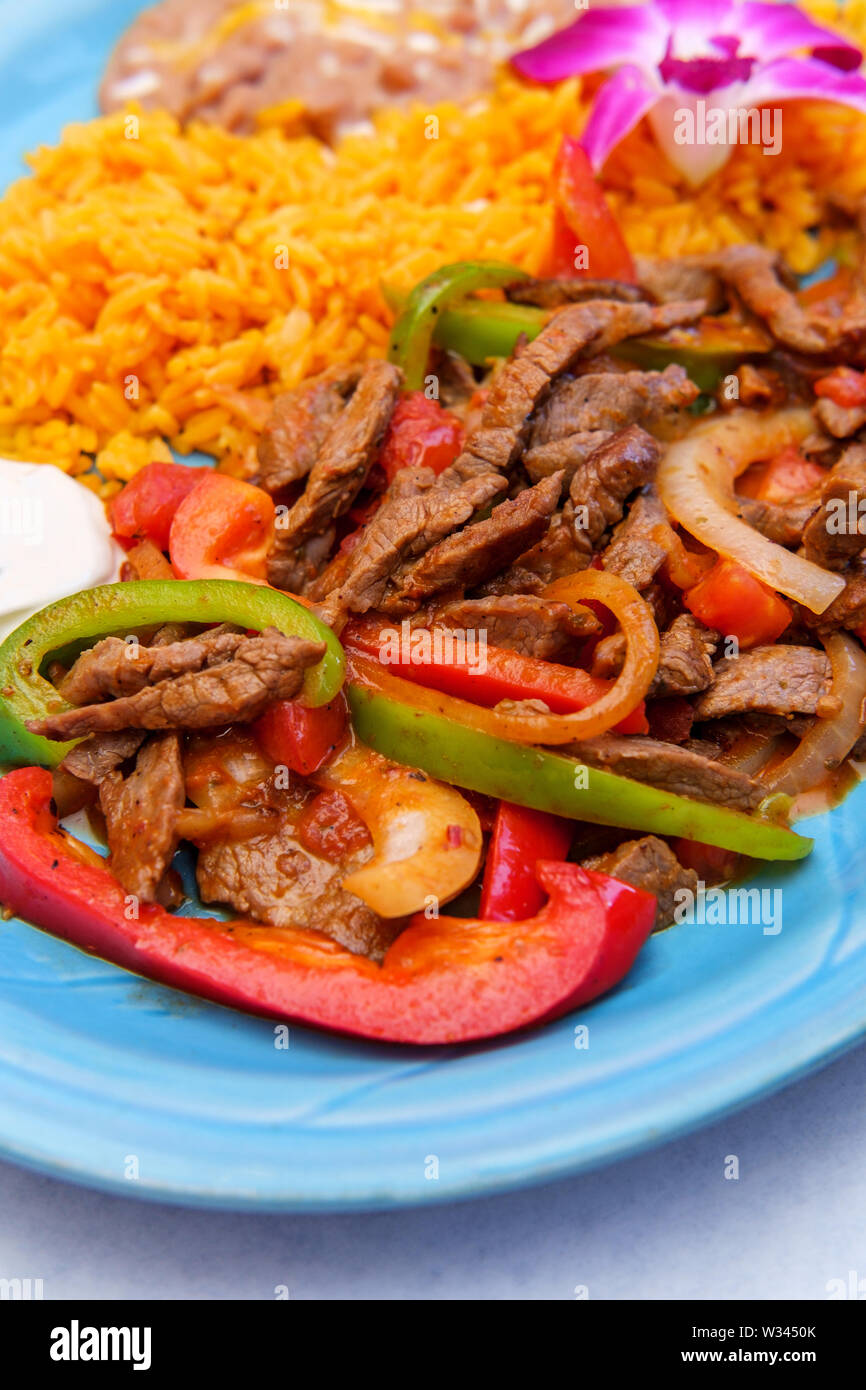 Authentic Mexican cuisine steak fajitas with rice and refried pinto