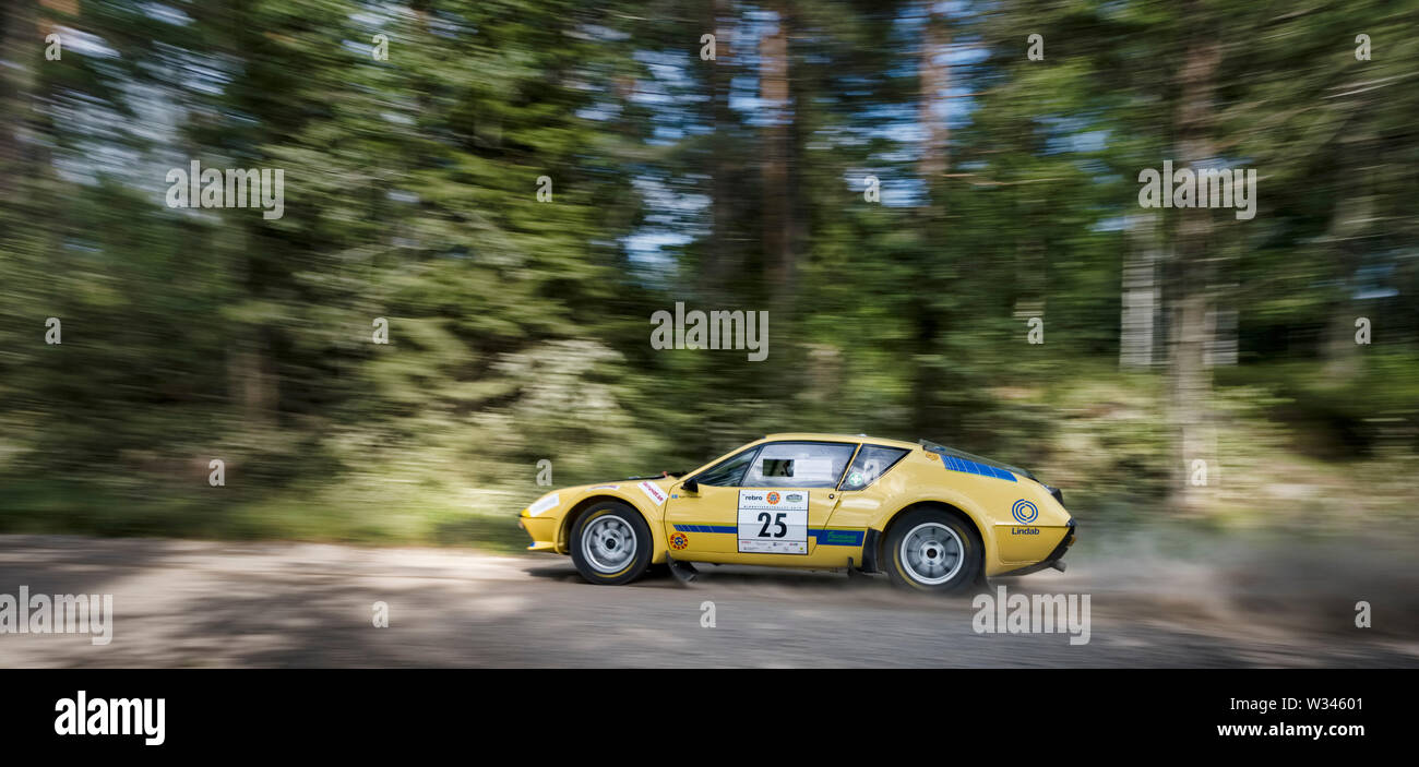 A yellow Renault Alpine A310 in full speed on a Swedish gravel road.The Swedish Rally to the midnight sun Stock Photo