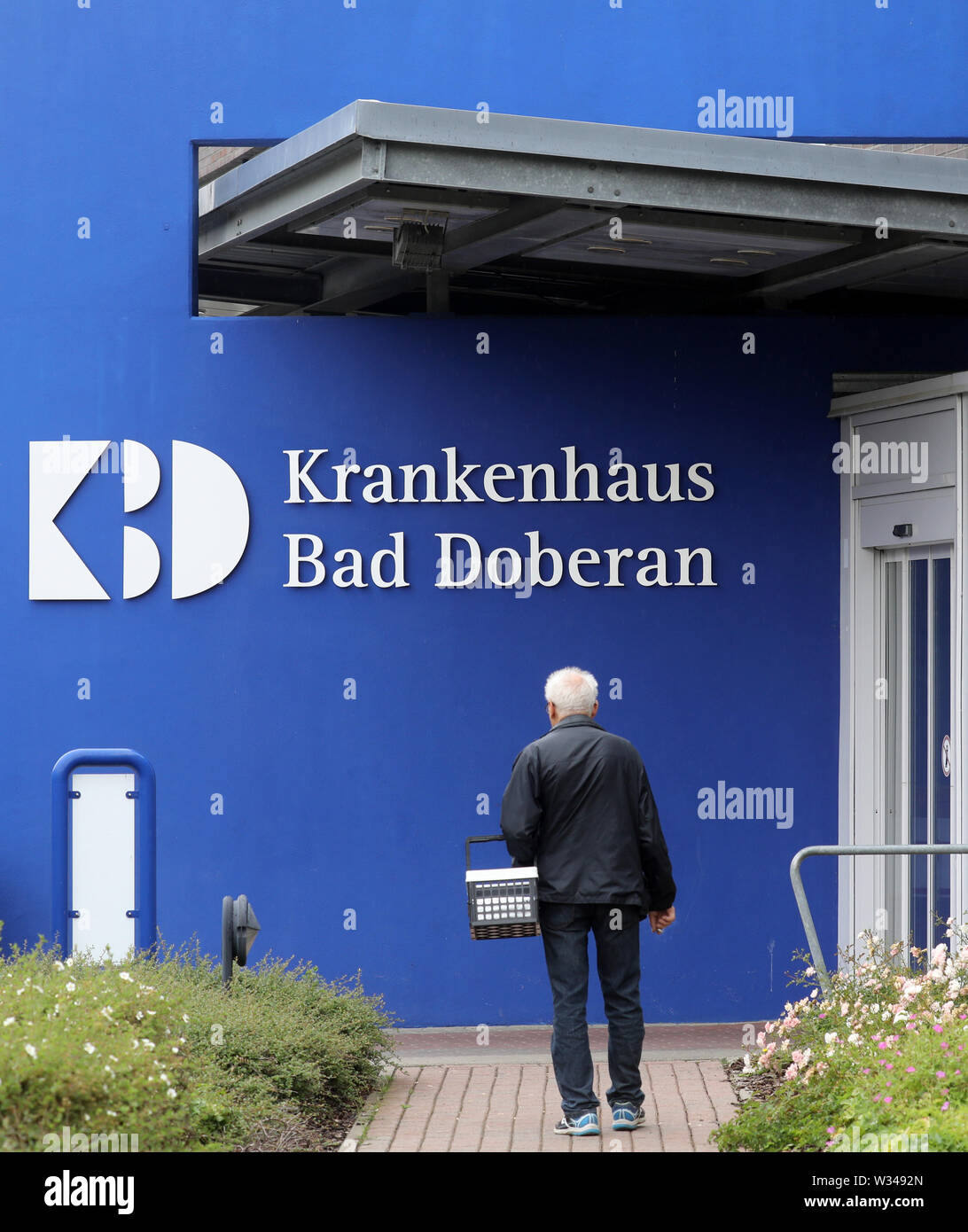 Bad Doberan, Germany. 12th July, 2019. A visitor goes to the clinic  entrance. The hospital is to be sold to Sana Kliniken AG, which is active  throughout Germany, and an agreement to