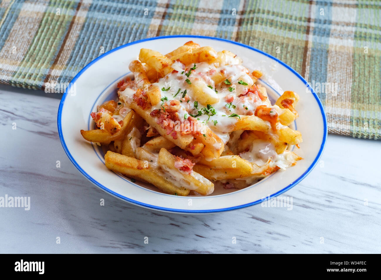 Crispy French fried potatoes loaded with bacon creamy ranch dressing and mozzarella cheese Stock Photo