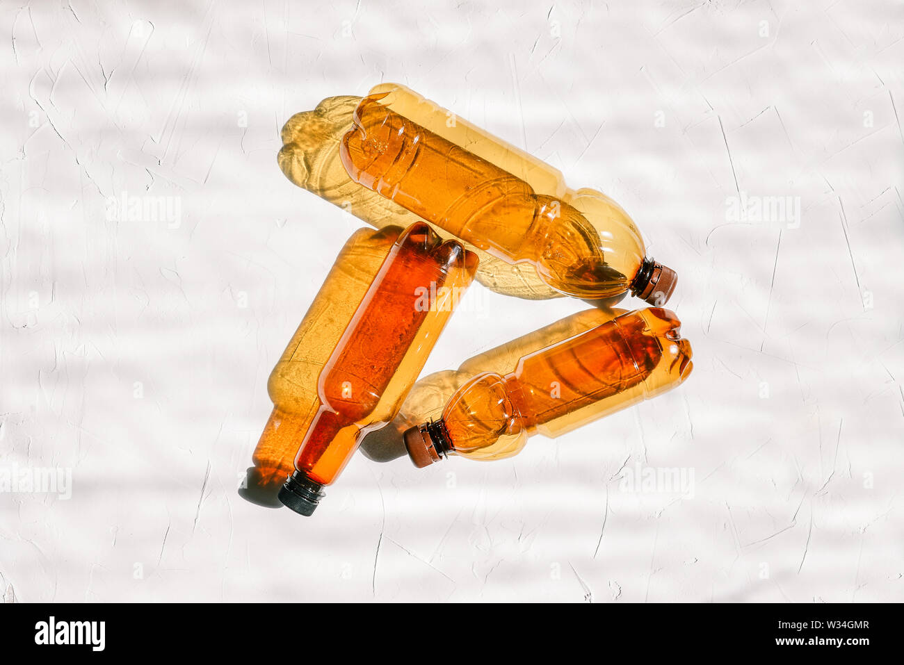 Background from empty plastic bottles. Three plastic bottles on a white background. The concept of land pollution by waste, recycling and recycling of Stock Photo