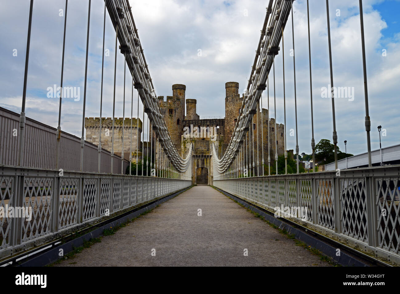 Conwy Suspension Bridge is a Grade I-listed structure built by Thomas Telford in 1822–26. It was designed to match the adjacent Conwy Castle. Stock Photo