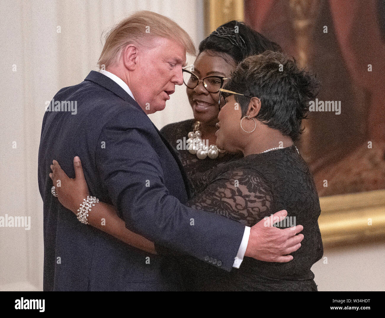 United States President Donald J. Trump hugs Diamond and Silk as he mentions them during his remarks at the Presidential Social Media Summit in the East Room of the White House in Washington, DC on Thursday, July 11, 2019.Credit: Ron Sachs/CNP /MediaPunch Stock Photo