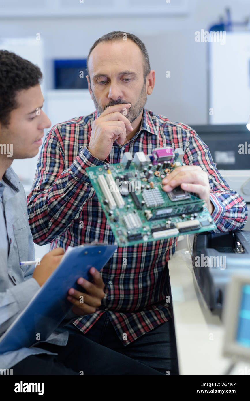 two technicians repairing a motherboard Stock Photo Alamy