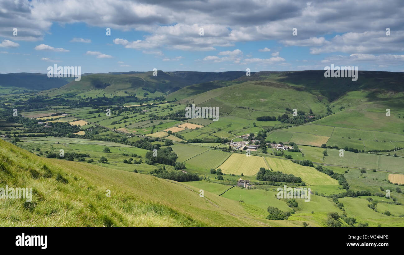 View across Edale valley and Kinder Scout plateau with white clouds and blue sky, Peak District, UK Stock Photo