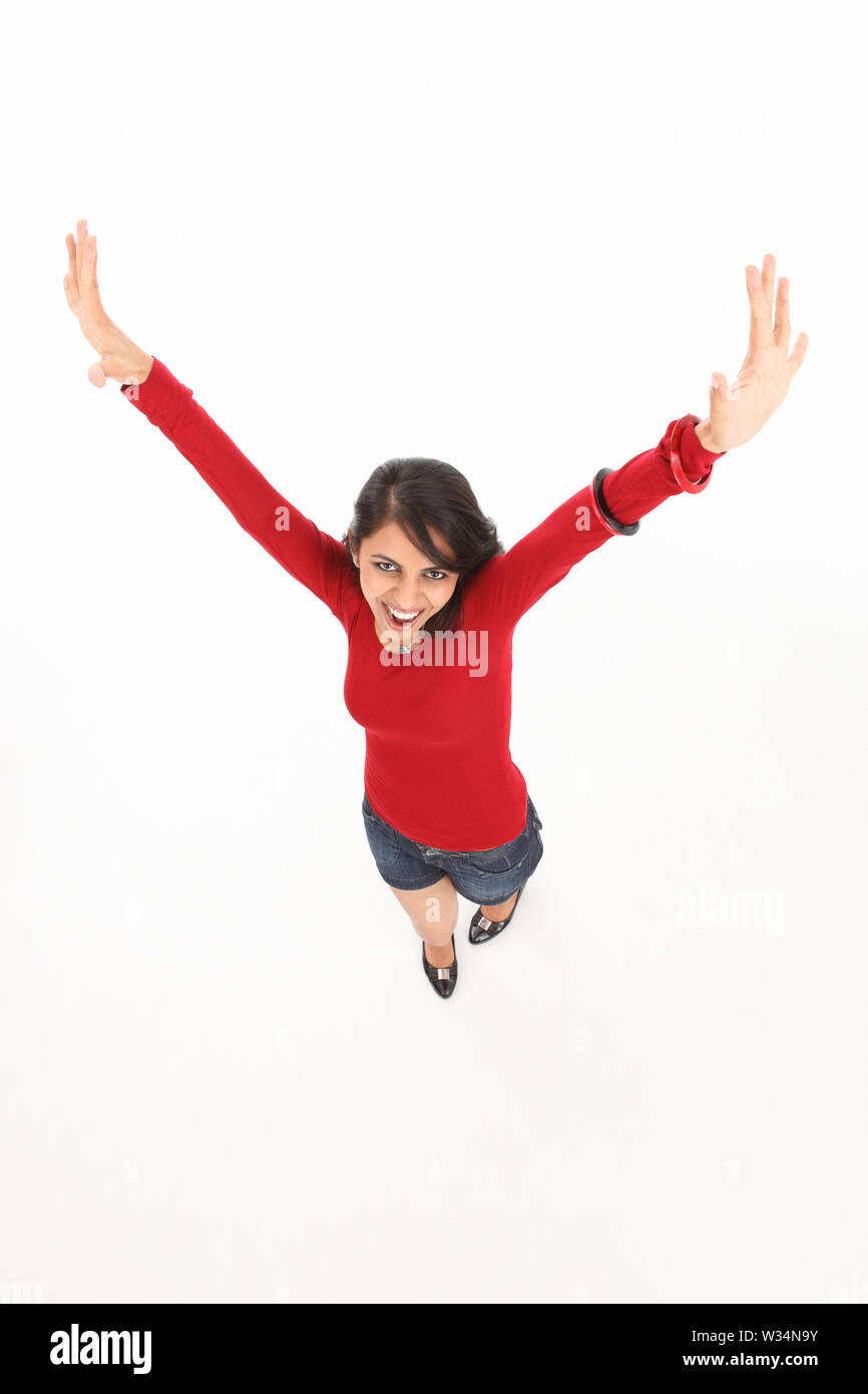 Portrait of a woman standing with her arms raised Stock Photo - Alamy