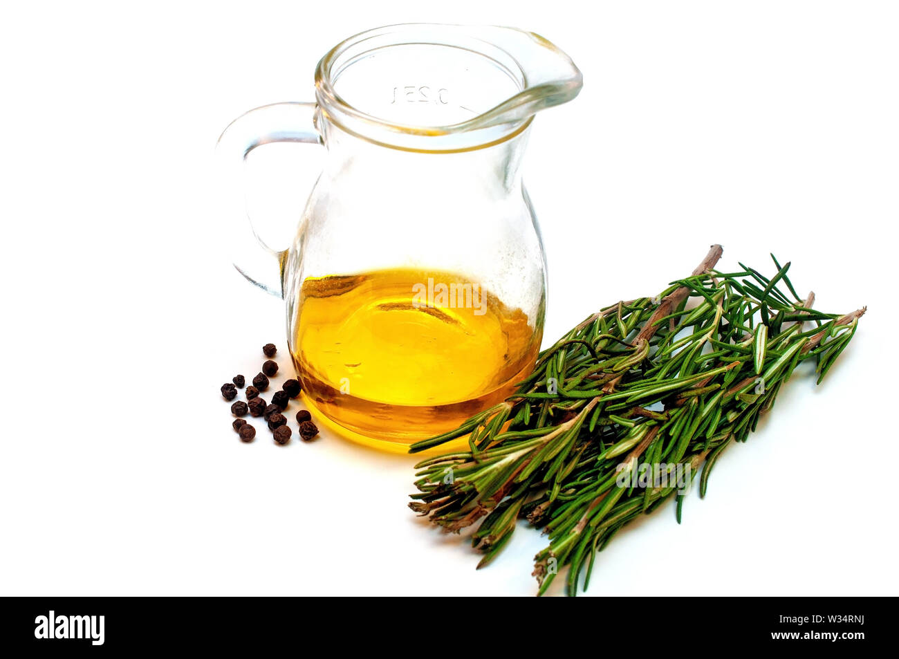 Olive oil in a jug and a branch of rosemary isolated on white Stock Photo