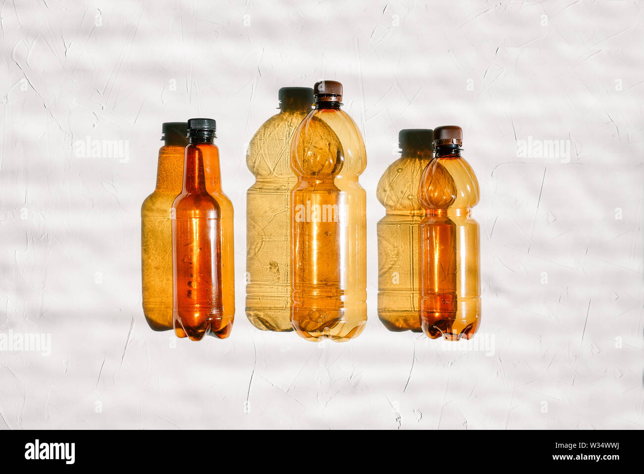 Background of plastic bottles. Three empty bottles in a row on a white ...