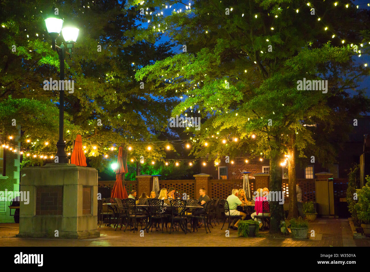 GREENVILLE, SC (USA) - July 5, 2019:  People eating at an outdoor cafe after dark in downtown Greenville. Stock Photo