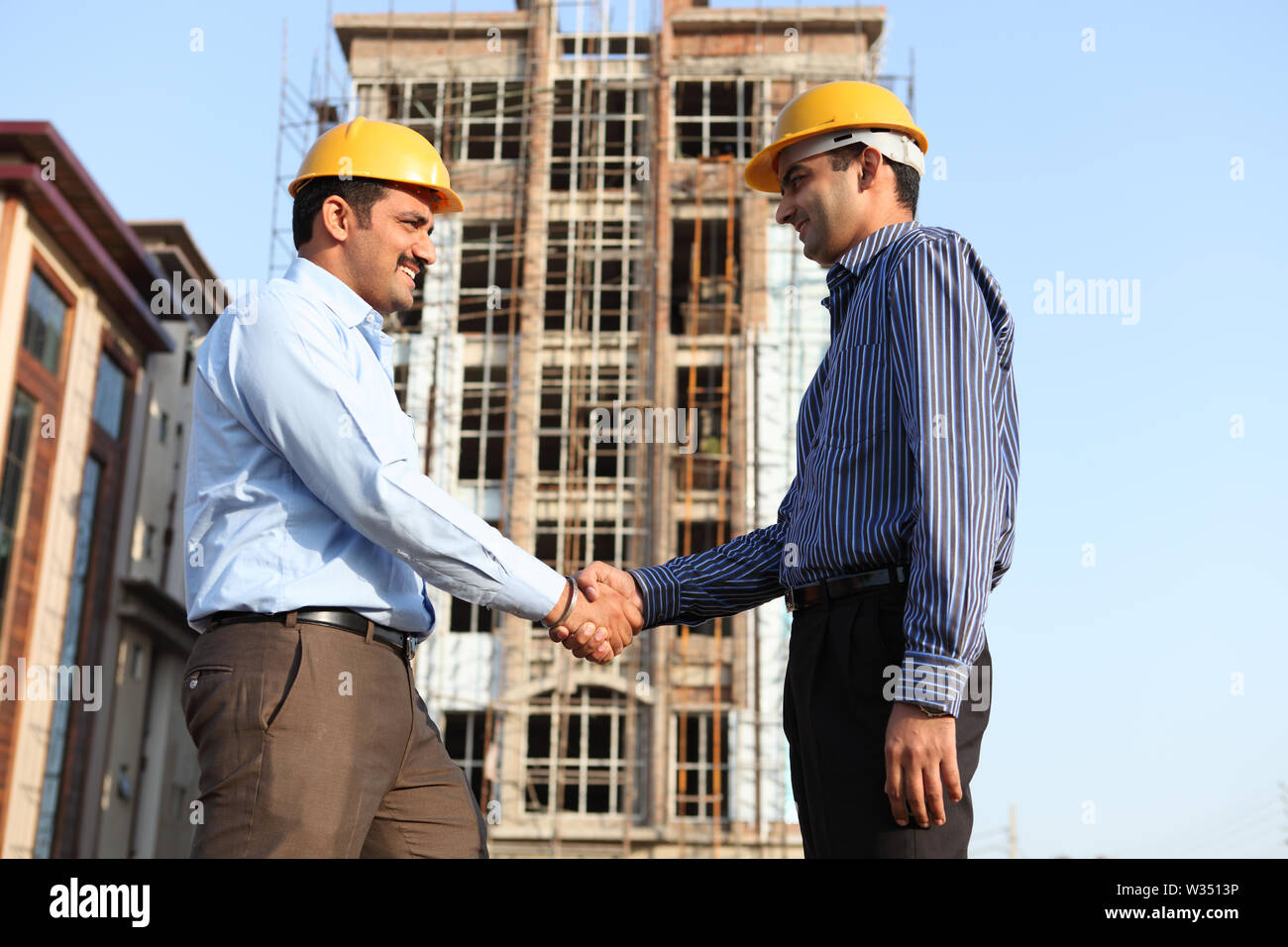 Two engineers shaking hands at a construction site Stock Photo Alamy