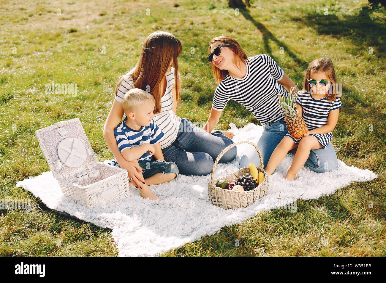 Mothers with kids playing in a summer park Stock Photo - Alamy