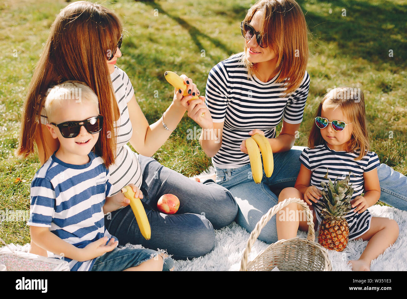 Mothers with kids playing in a summer park Stock Photo - Alamy