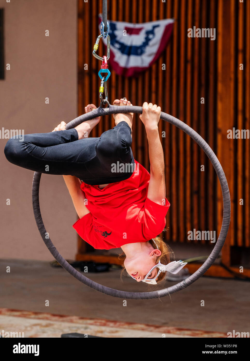 Young girl performing on circus rings hoops Lyras; Fourth of July event
