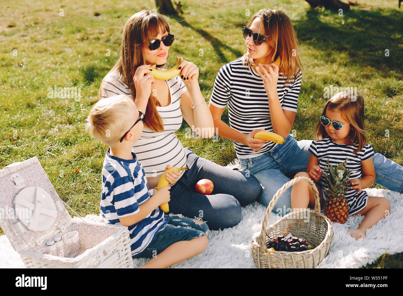 Mothers with kids playing in a summer park Stock Photo - Alamy