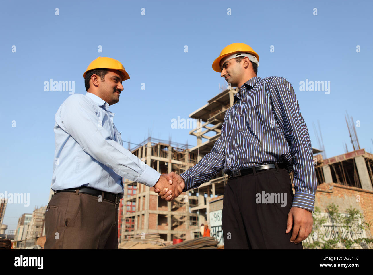 Two engineers shaking hands at a construction site Stock Photo Alamy