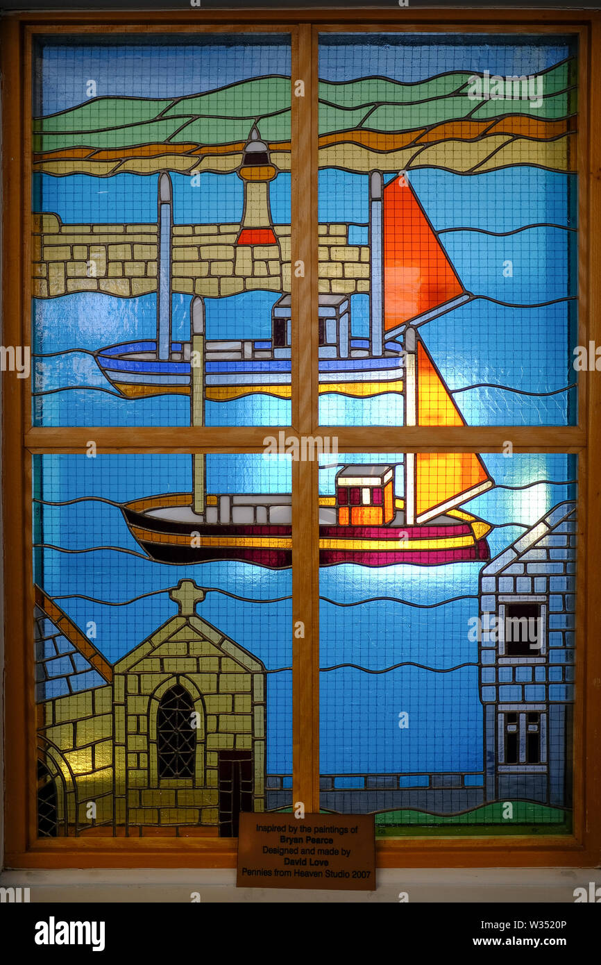 Colourful stained glass window display showing harbour scene in St Ives Library. Stock Photo