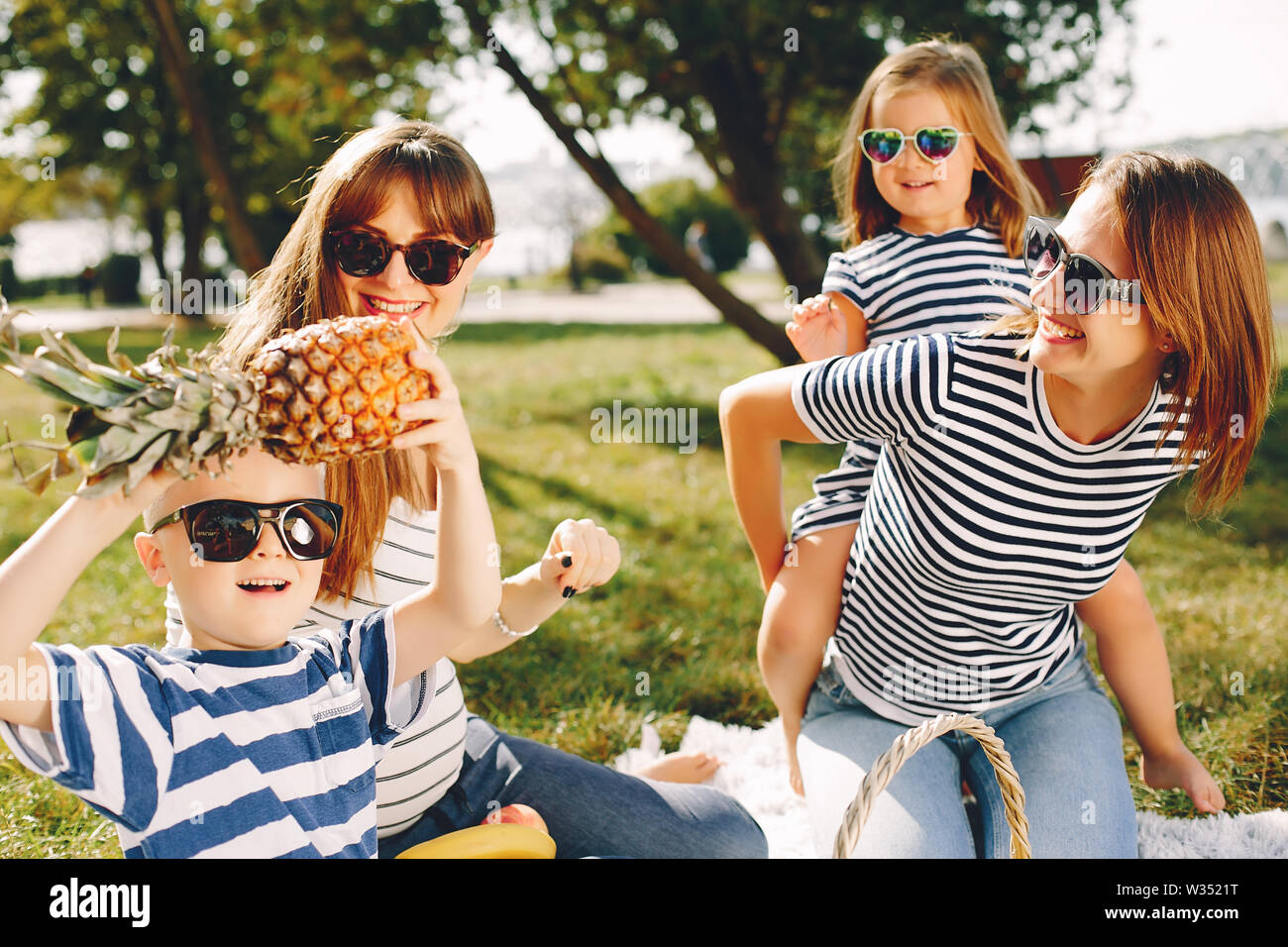 Mothers with kids playing in a summer park Stock Photo - Alamy