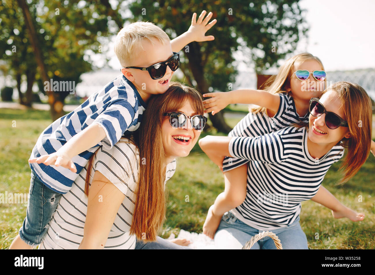 Mothers with kids playing in a summer park Stock Photo - Alamy
