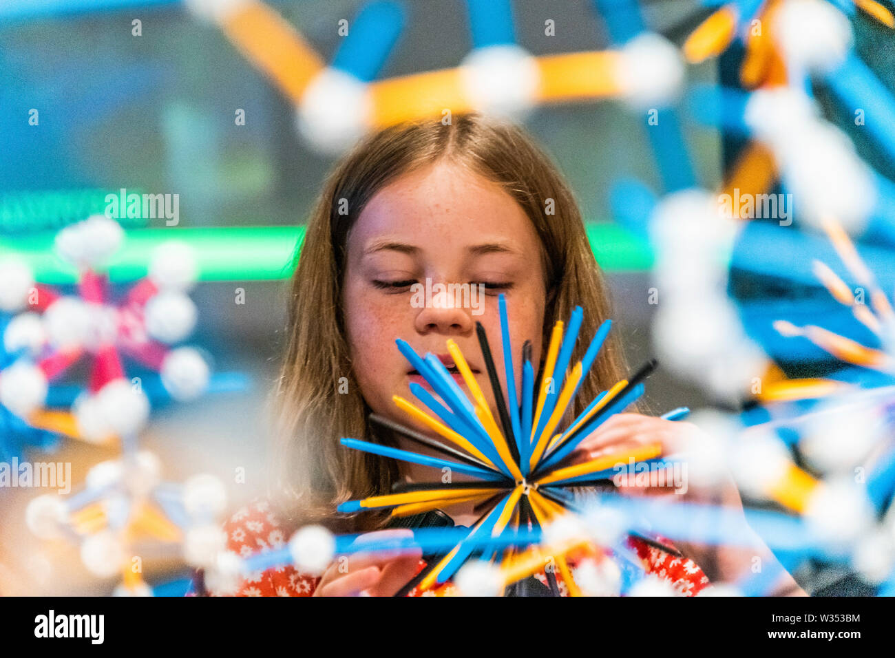 London, UK. 12th July, 2019. . 12th July, 2019. People of all ages build with specially created building pieces in The Structural Evolution Project 2001 - Olafur Eliasson: In real life at Tate Modern. Sixteen years since his sun installation in Tate Modern's Turbine Hall, In real life is a survey spanning over 30 years of Eliasson’s career. Featuring over 40 works - most of which are shown in the UK for the first time - this exhibition examines the artist’s engagement with some of today's most urgent issues, from climate change to migration. Credit: Guy Bell/Alamy Live News Credit: Guy Bell/Al Stock Photo
