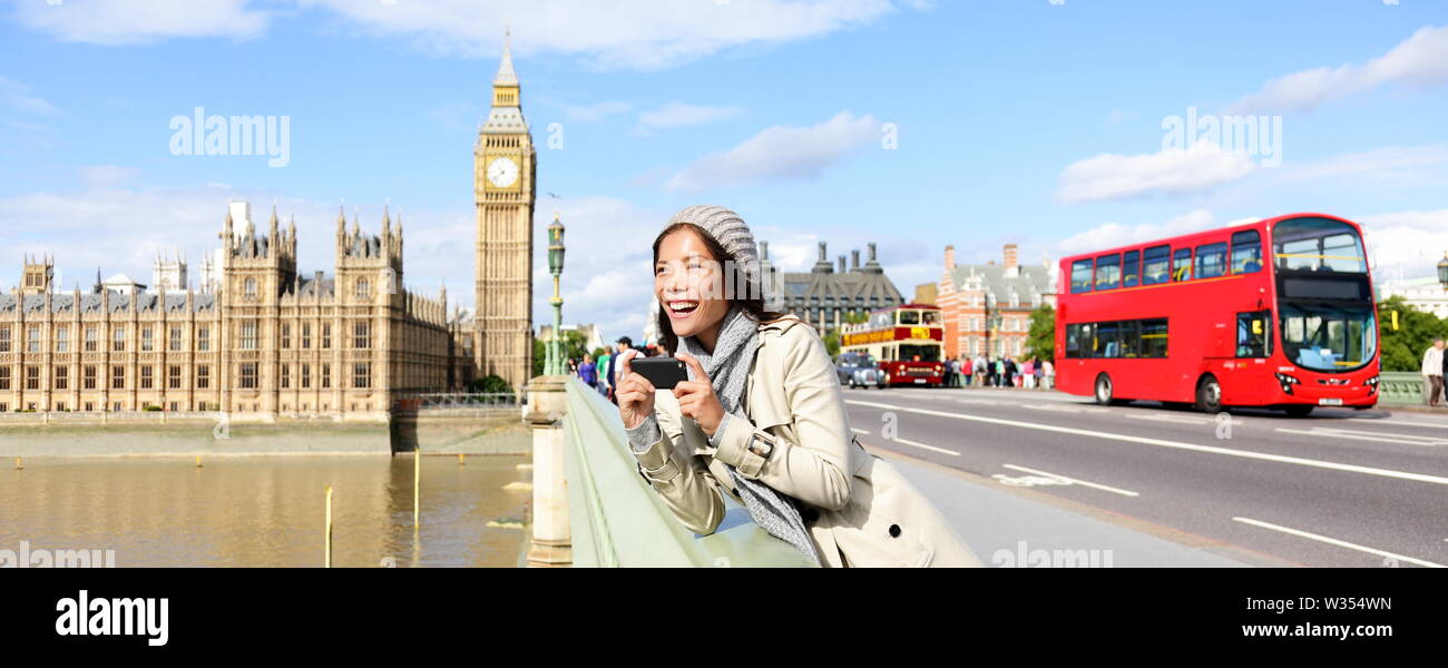London travel banner with woman tourist, Big Ben and red double decker bus. Girl taking photo on Westminster Bridge with smartphone camera over River Thames, London, England, Great Britain, UK. Stock Photo