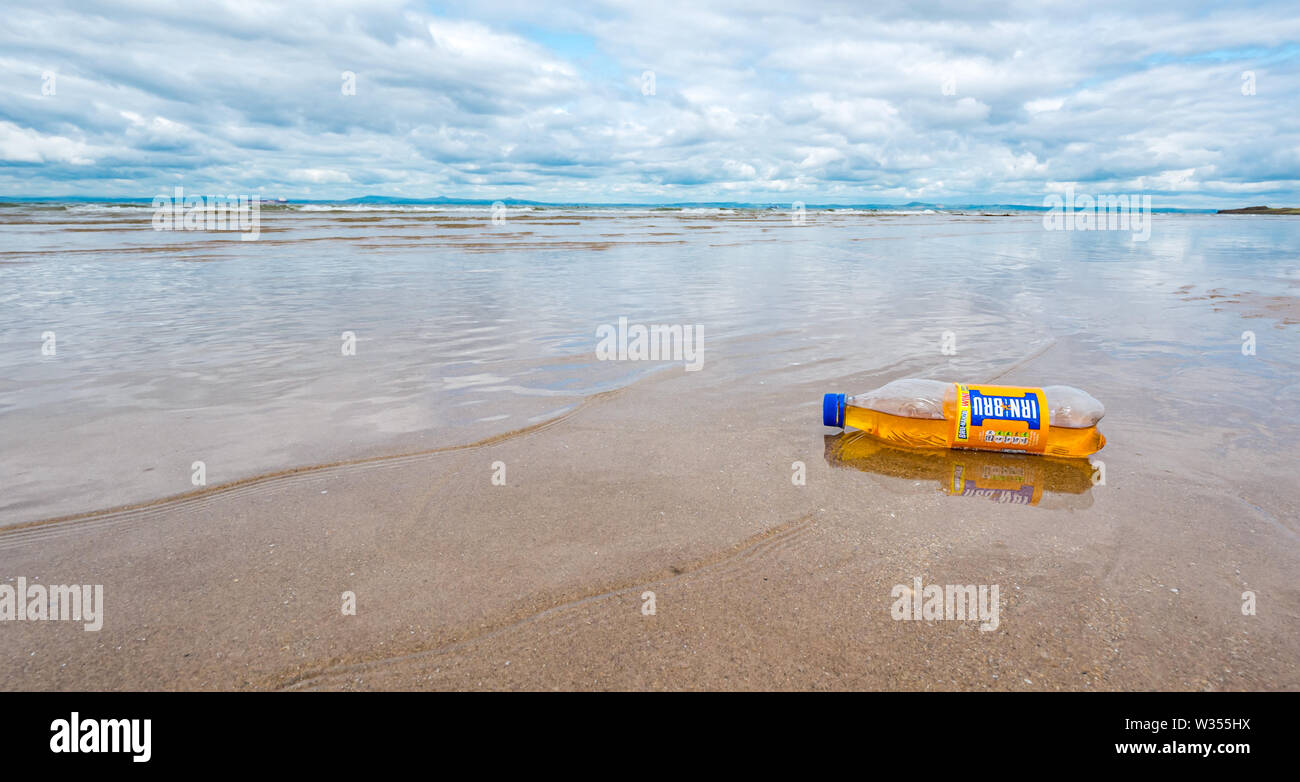 Irn Bru plastc bottle waste rubbish washed up on sandy beach, Aberlady Nature Reserve, East Lothian, Scotland, UK Stock Photo