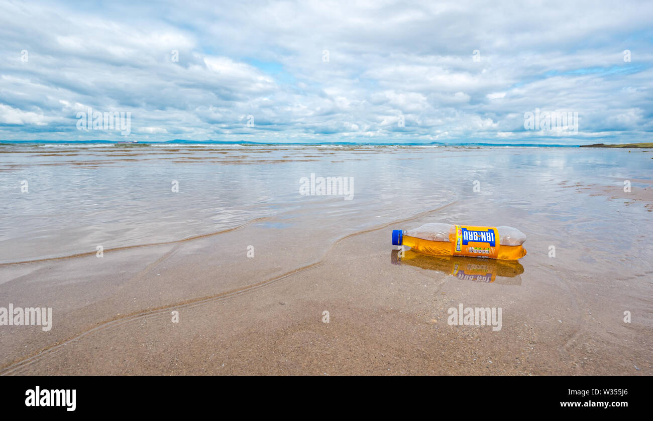 Irn Bru plastc bottle waste rubbish washed up on sandy beach, Aberlady Nature Reserve, East Lothian, Scotland, UK Stock Photo