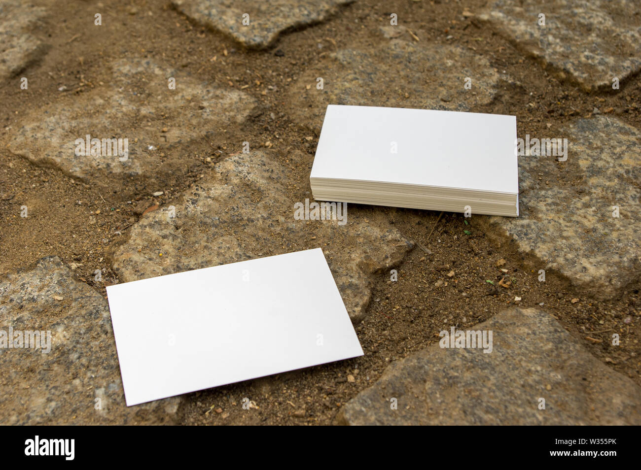 Empty Mockup Business Cards Stacked On Cobblestone Flooring Stock