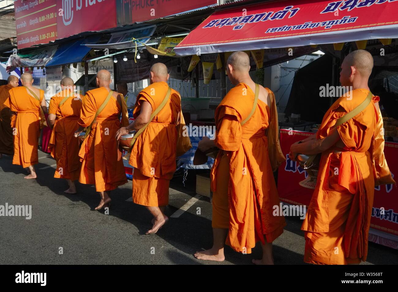 Buddhist monks living at the Big Buddha Temple on Phuket on a morning alms round at Phuket Town, Phuket, Thailand Stock Photo