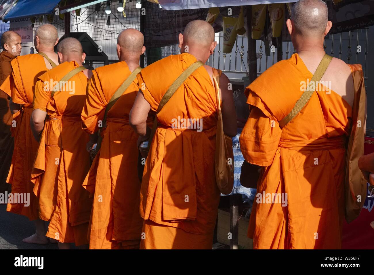 Buddhist monks living at the Big Buddha Temple on Phuket on a morning alms round at Phuket Town, Phuket, Thailand Stock Photo