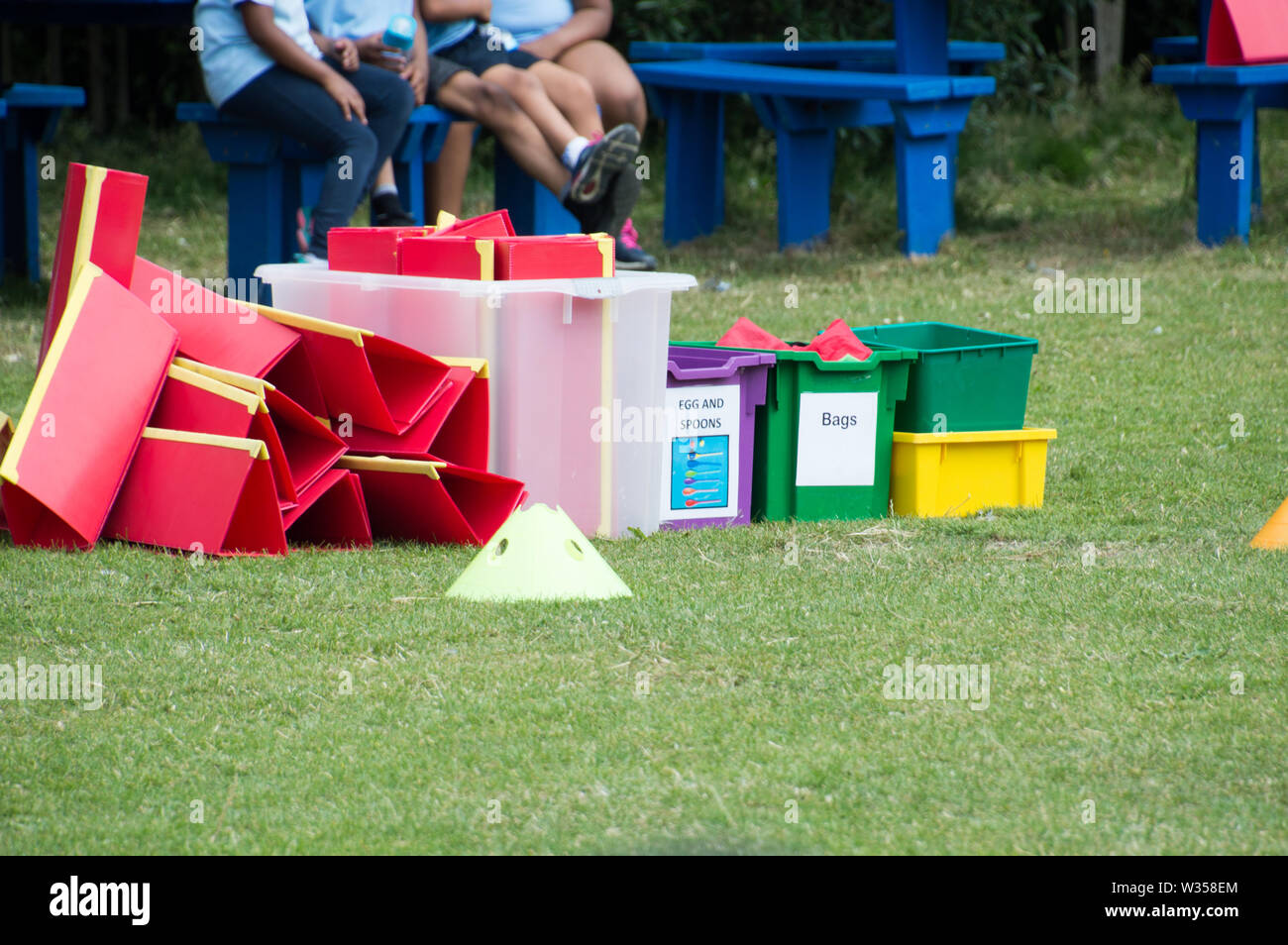 Sports day equipment in a box with school children in background Stock