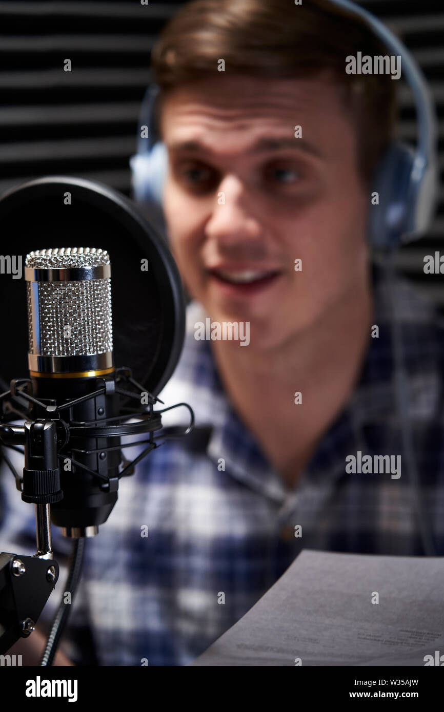 Man In Recording Studio Talking Into Microphone Stock Photo