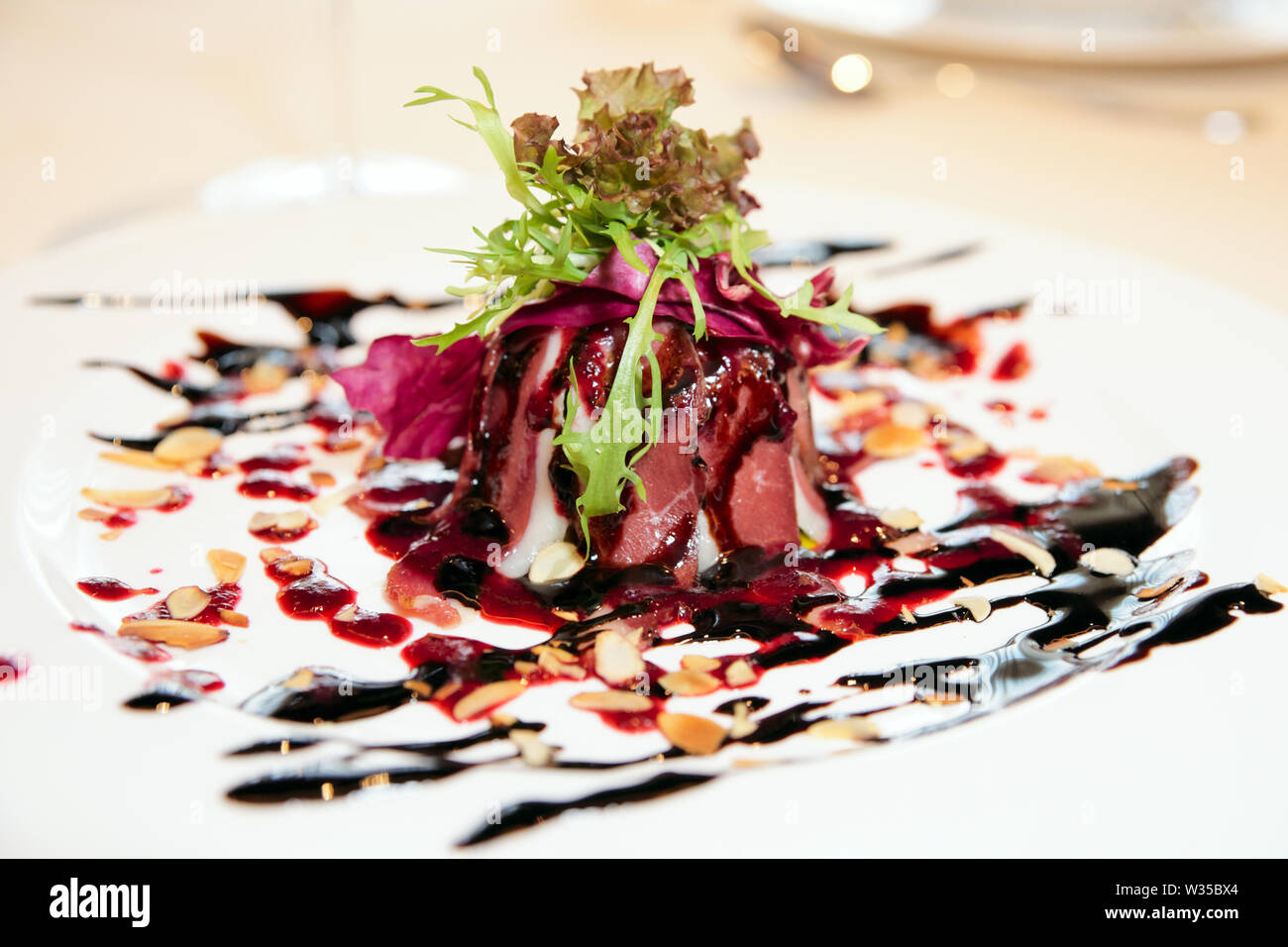 Smoked duck salad decorated with berry sauce and cream balsamic vinegar Stock Photo