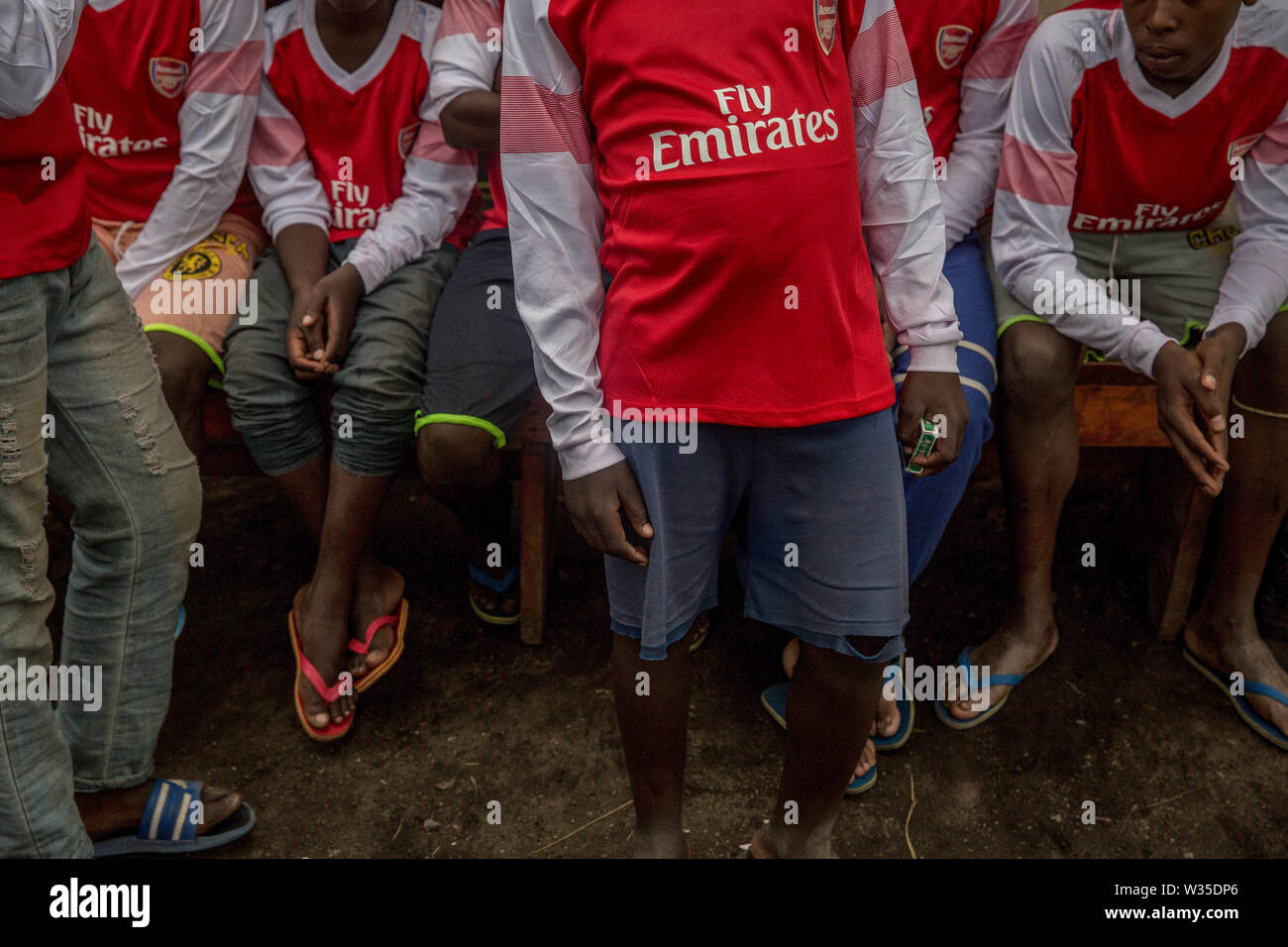 Former child soldiers pose for a photo dressed in Arsenal Fly Emirates jerseys at a Transit Centre in Goma. Hundreds will spend several months here before being reintegrated into the community. UNICEF is working with MONUSCO (UN DRC stabilization mission) to support some of the tens of thousands of child soldiers that have been recruited in eastern DRC since 2013. Stock Photo