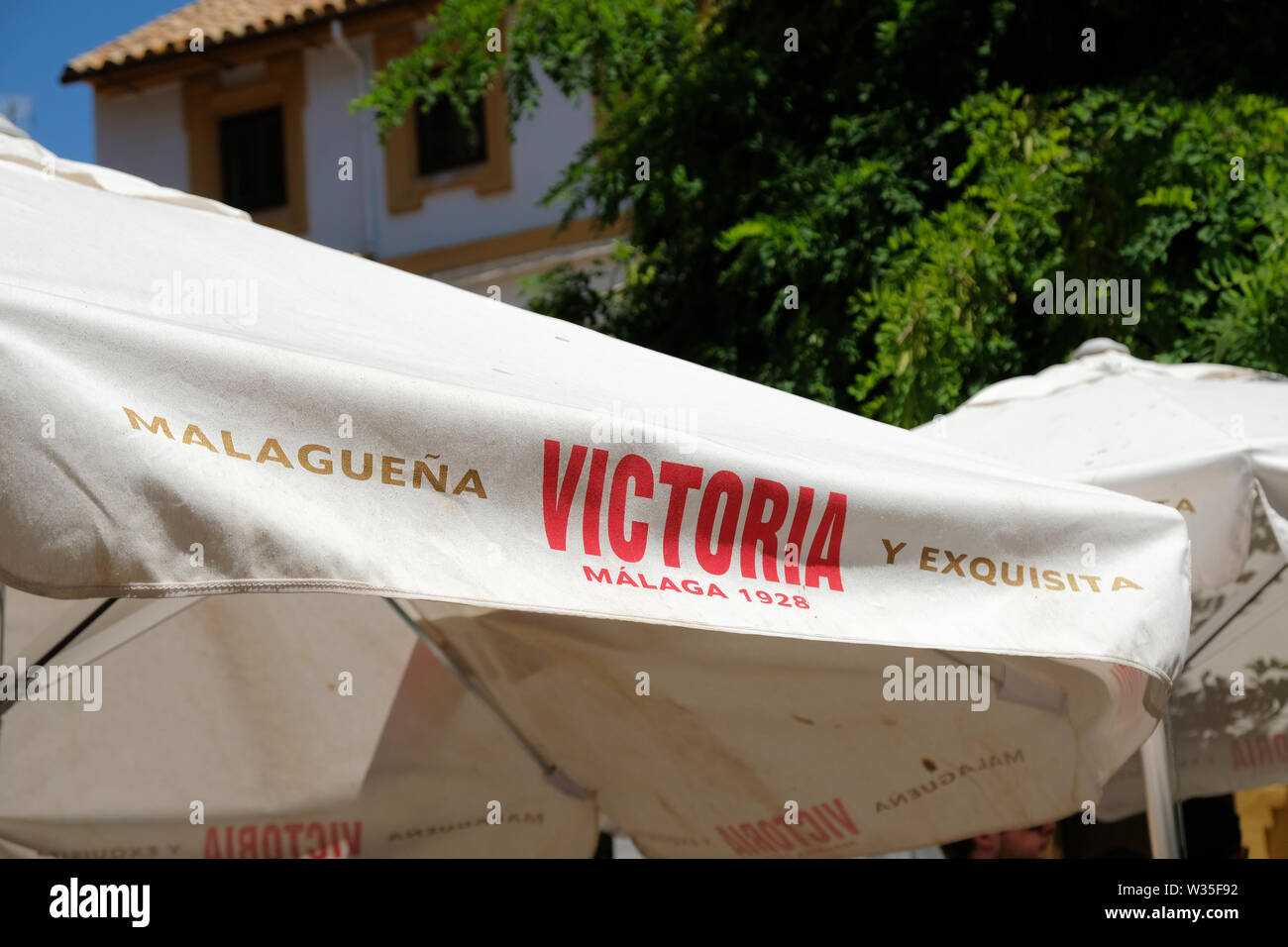 Advertisement for Victoria Beer, established in Malaga in 1928, on the edge of an umbrella cover in a patio restaurant in Cordoba, Spain. Stock Photo