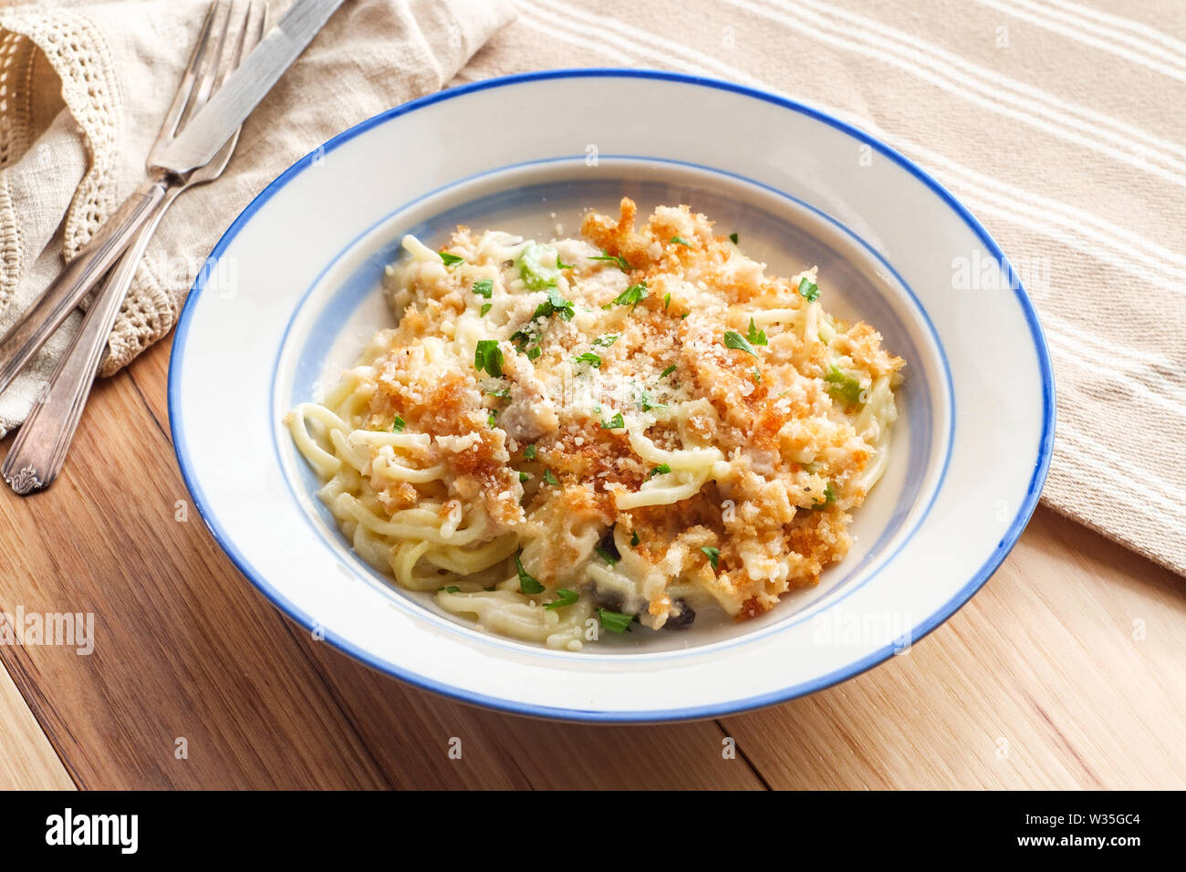 Creamy baked chicken alfredo with spaghetti pasta topped with parmesan