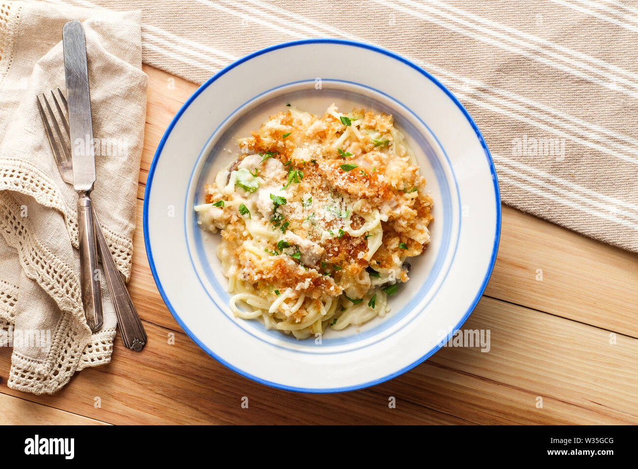 Creamy baked chicken alfredo with spaghetti pasta topped with parmesan