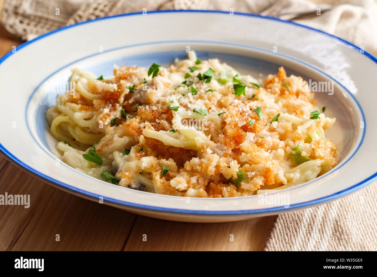 Creamy baked chicken alfredo with spaghetti pasta topped with parmesan