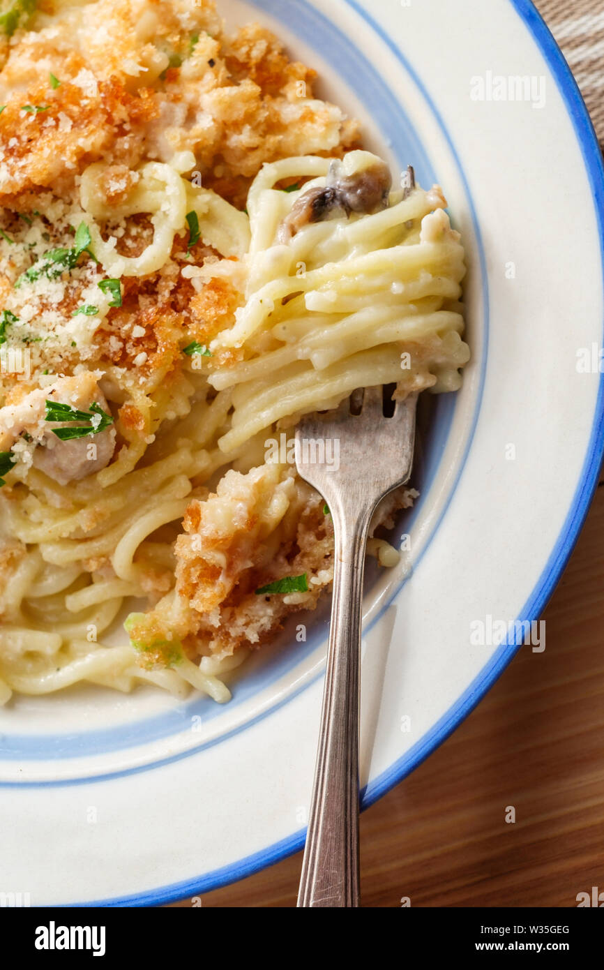 Creamy baked chicken alfredo with spaghetti pasta topped with parmesan