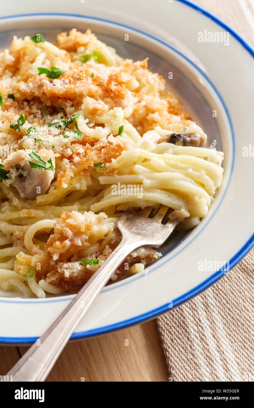 Creamy baked chicken alfredo with spaghetti pasta topped with parmesan