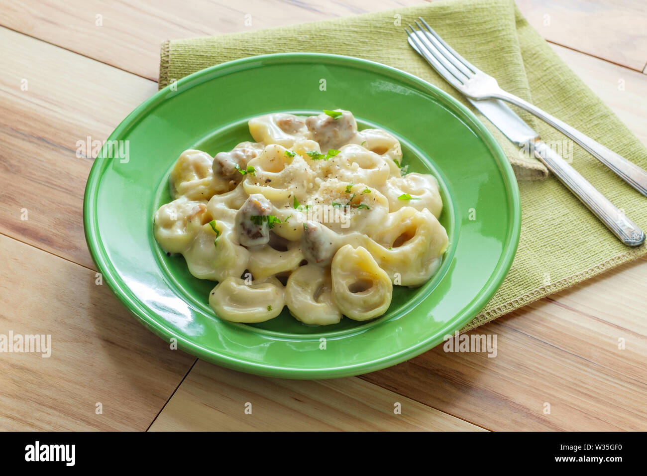Butter and parmesan cheese tortellini alfredo with Italian sausage