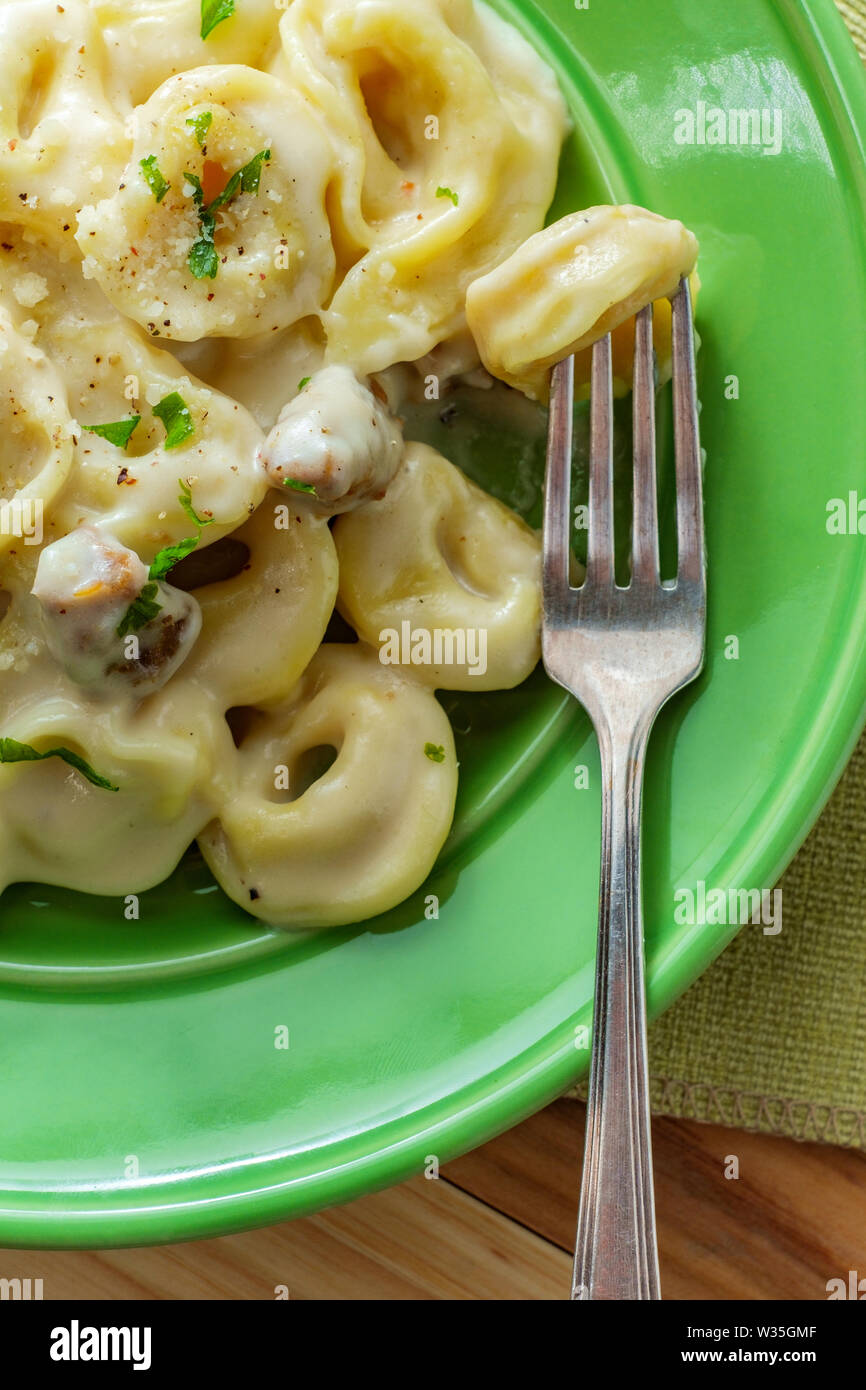 Butter and parmesan cheese tortellini alfredo with Italian sausage
