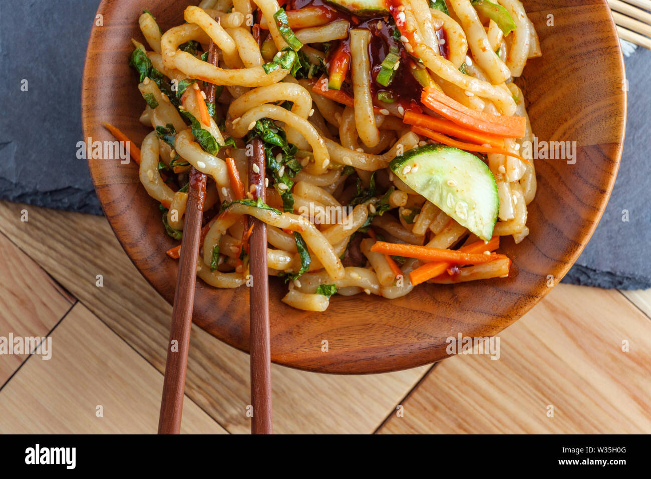 Stirfried kimchi udon noodle bokkeum with fresh kirby cucumber carrots and gochujang suace