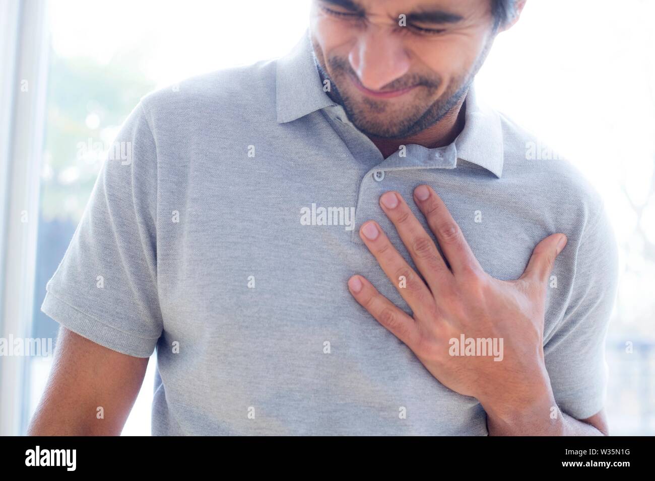 Man touching his chest in pain. Stock Photo