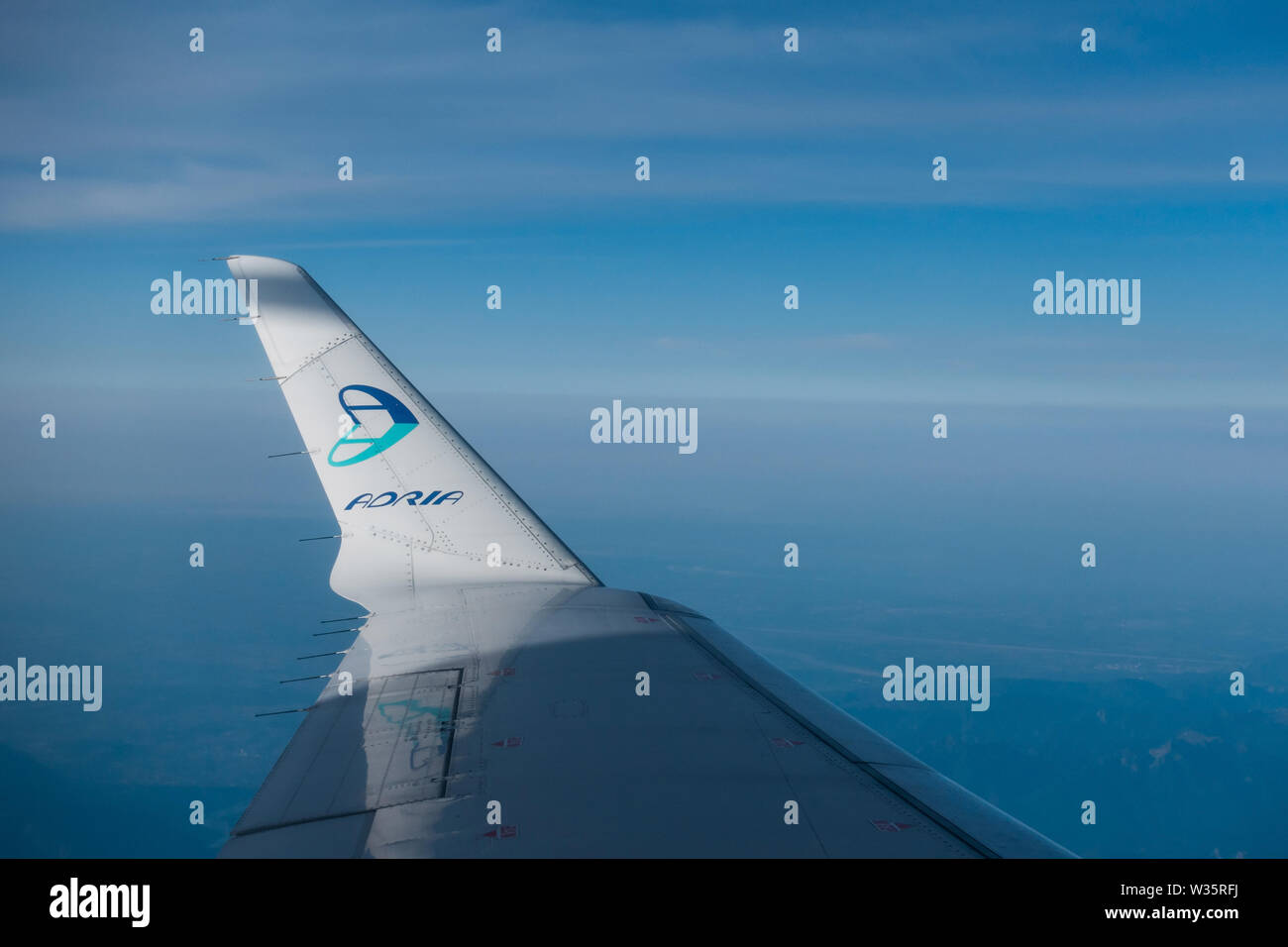 Airplane wing with Adria Airways logo on winglet, airplane in flight Stock Photo