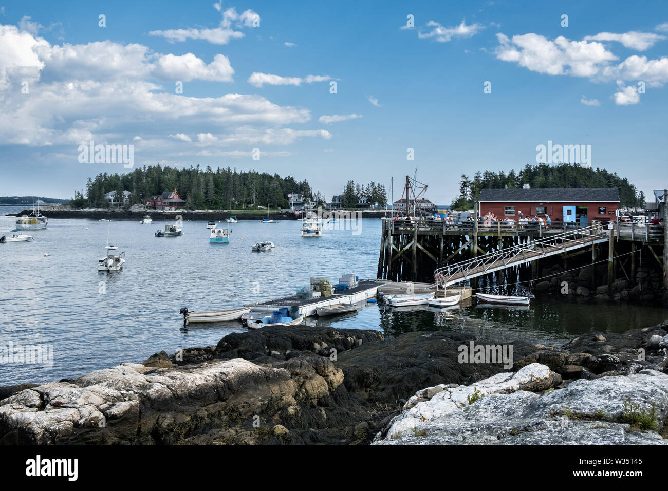 View of Five Islands Harbor with the lobster wharf, restaurant and boats moored in Georgetown, Maine. Stock Photo